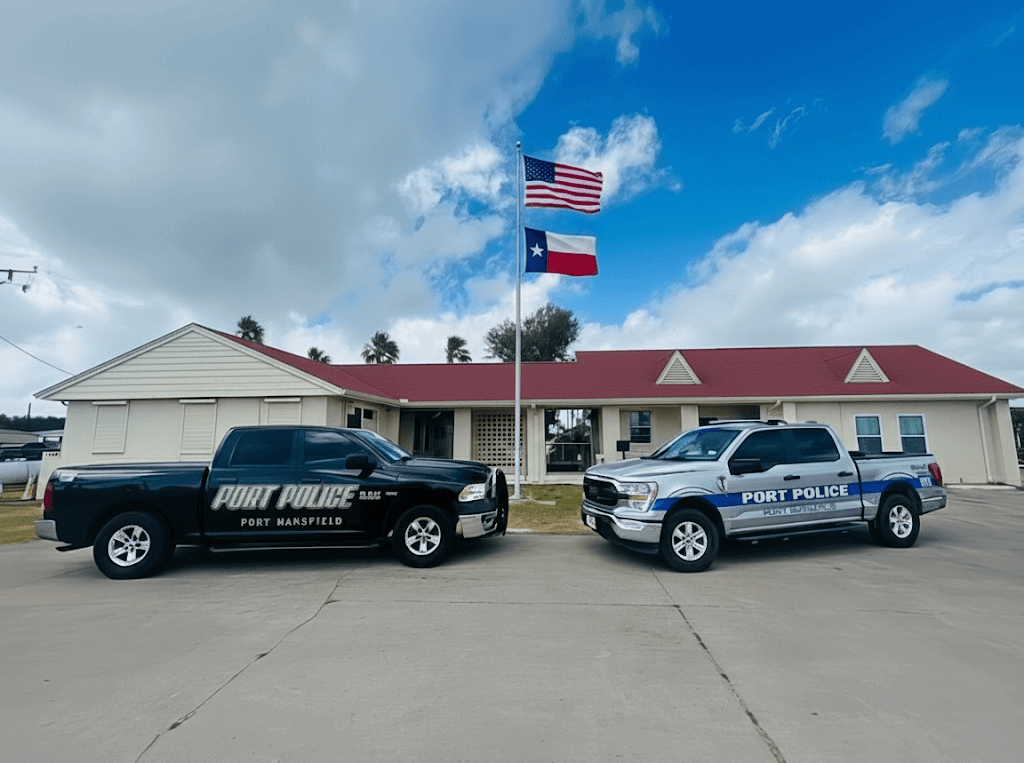Port Mansfield Police Department building with American and Texas flags and patrol vehicles